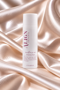 A white cylindrical bottle of ALIGN Skincare 'moisturize me' eye serum, set against a luxurious draped satin fabric backdrop in warm champagne tones.
