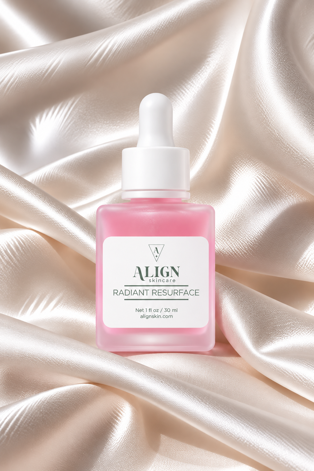 A bottle of ALIGN AESTHETICS Radiant Resurface serum with pink liquid and a white dropper cap, set against a draped champagne satin background.